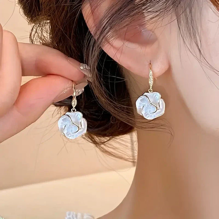 Elegante gouden oorbellen met witte spiraalvorm